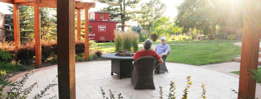 People conversing around a patio table behind the QuietWaters Retreat Center