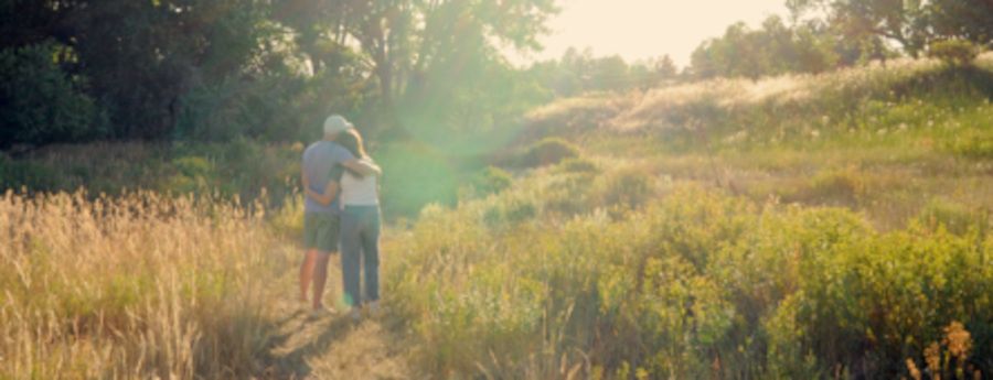 Couple hugging in the sunlight on a trail at the QuietWaters retreat center